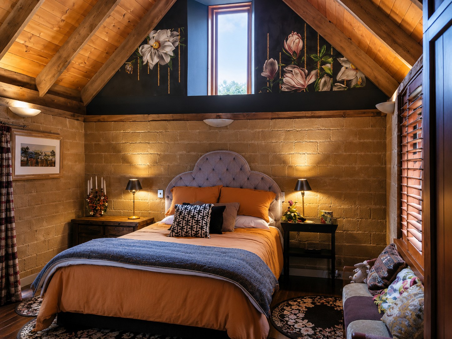 Timber A-frame attic bedroom with magnolia wallpaper and a burnt-orange bed