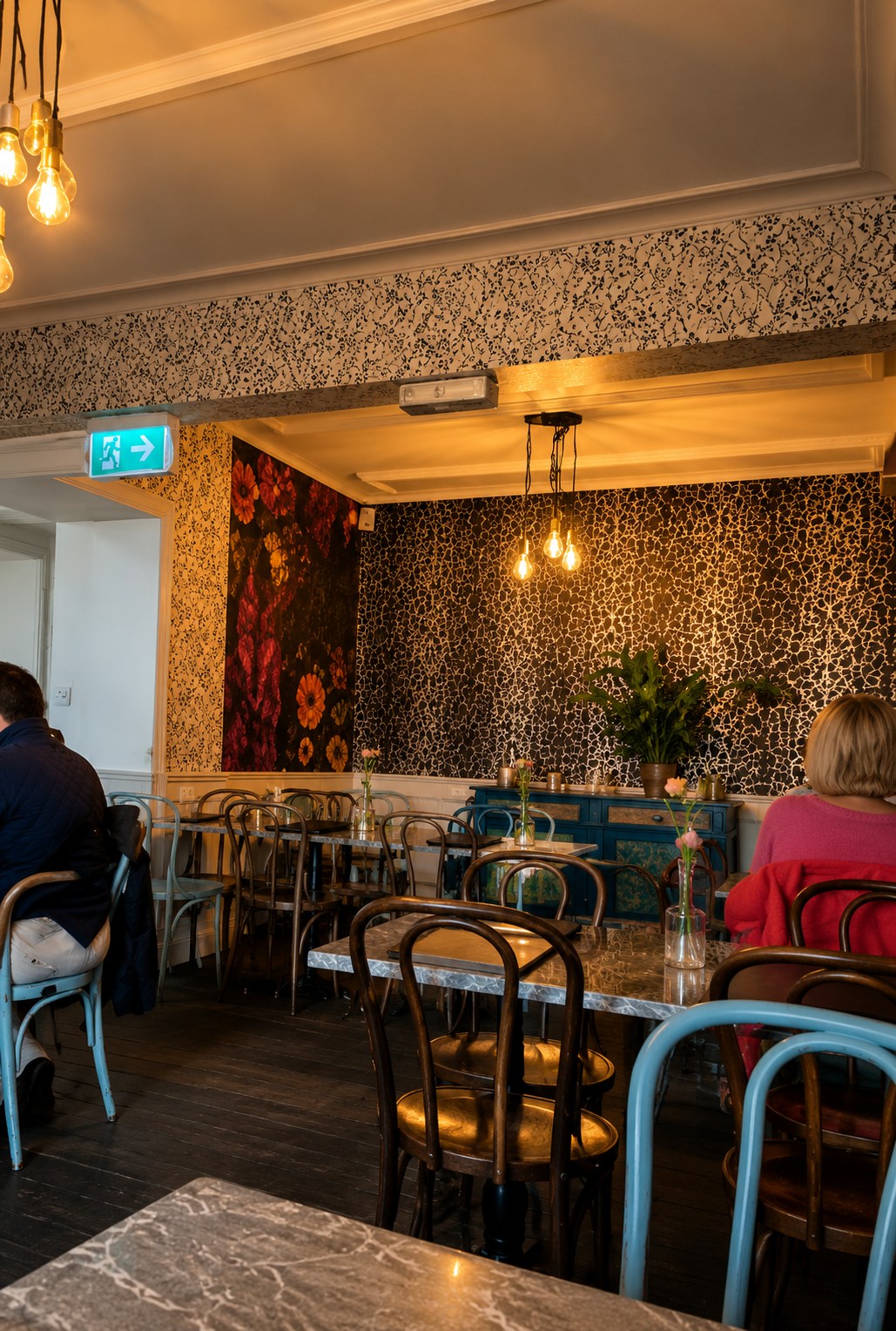 Eclectic café interior with leopard-print wallpaper and bentwood chairs